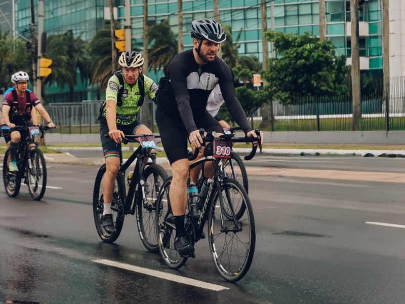 Ciclistas em treino com pista molhada